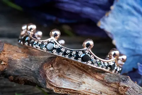 Ein ausgefallener Verlobungsring aus Rotgold, in Form einer Krone, mit schwarzen Brillanten, als Vorsteckring geeignet