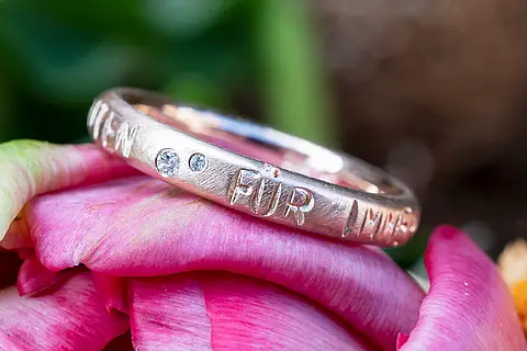 Ein ganz persönlicher Verlobungsring mit zwei kleinen Brillanten und einer seidenmatten Oberfläche