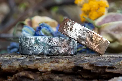 Außergewöhnliche Eheringe aus Weißgold und Rosé-Palladium mit einer farbigen liquid Oberfläche im rustikalen Design