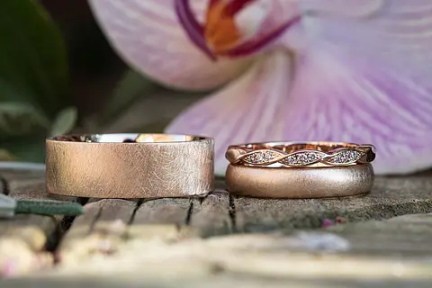 Eheringe im Vintage Stil aus Rotgold und Roségold mit einem Verlobungsring und kleinen Steinen (Brillanten). Die Oberfläche ist eismatt beim Herrenring und seidenmatt beim Damenring