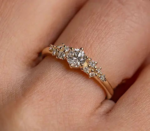 Verlobungsring aus Roségold mit Diamanten an einer Frauenhand.