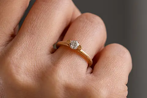 Verlobungsring aus Roségold mit einem Solitär Diamanten an einer Hand