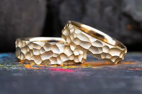 Goldene Eheringe mit einer auffälligen rustikalen Oberfläche