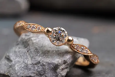 Verlobungsring aus Rotgold mit Diamant als Mittelstein und besetzter Ringschiene
