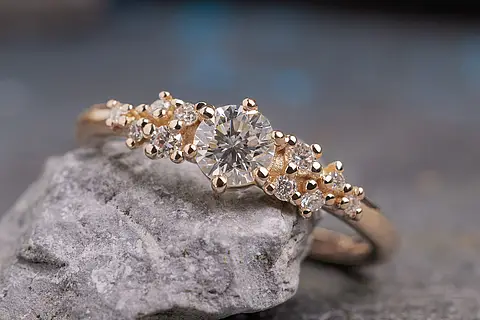 Verlobungsring Rosalie aus Roségold mit einem Diamanten als Mittelstein und mehreren unterschiedlich großen Diamanten daneben