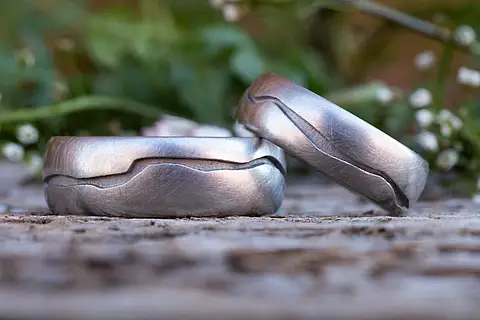 Individuelle Eheringe silber aus Platin. In die Ringoberfläche ist ein Abschnitt der Isar eingraviert.