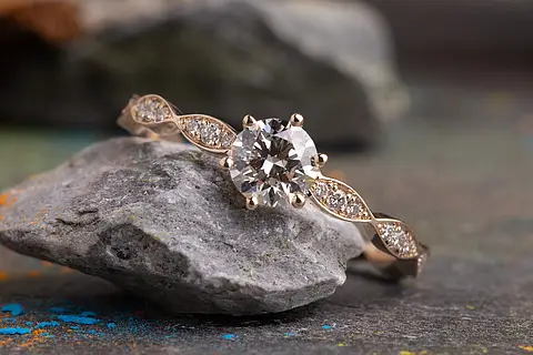 Verlobungsring Rosalie aus Roségold mit einem Diamanten als Mittelstein und besetzter Ringschiene
