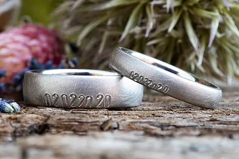 Silberne Eheringe aus Platin mit eingestempelten Ziffern