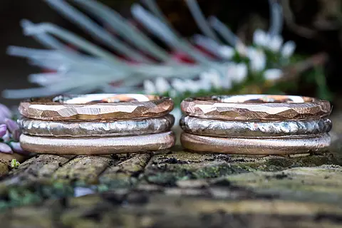 Ein Eheringpaar bei dem jeder Ring aus drei Einzelringen aus unterschiedlichen Materialien mit verschiedenen Oberflächen besteht