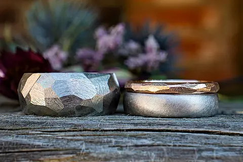 Besondere Eheringe mit einer ausgefallenen rustikalen Struktur und einem rotgoldenen Vorsteckring