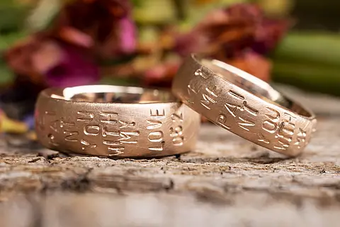 Individuelle Eheringe aus Rotgold mit eingestempelten Worten