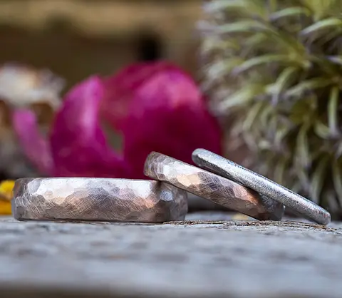 Eheringe Hammerschlag aus Rosépalldium kombiniert mit einem Vorsteckring aus Platin.