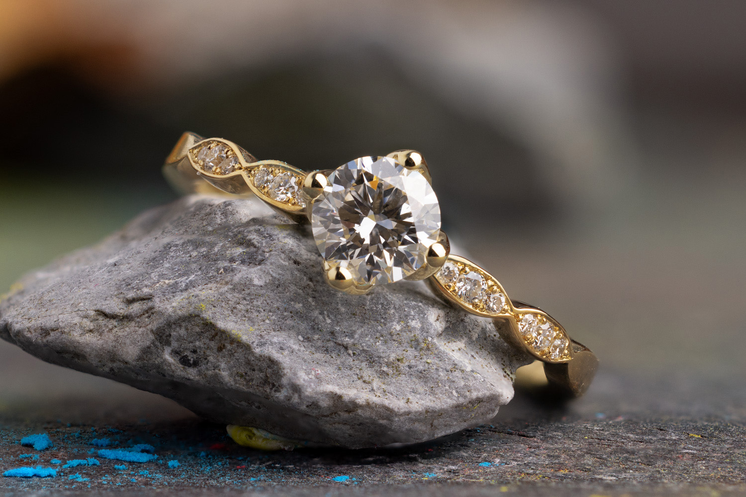 Verlobungsring Belle aus Gelbgold mit Diamant Mittelstein und kleinen Diamanten entlang der Ringschiene