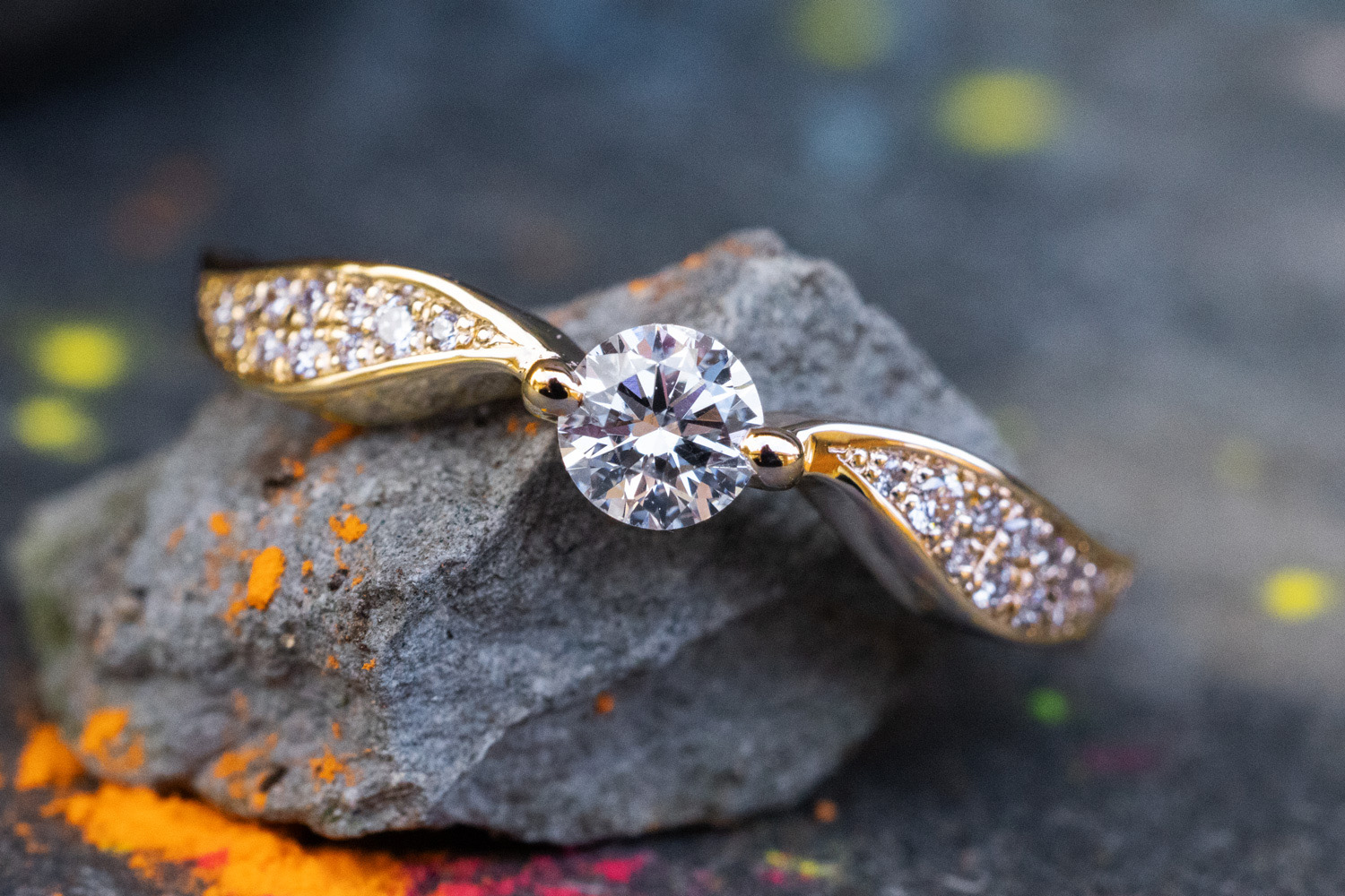 Verlobungsring Schnatz aus Gelbgold mit Diamant Mittelstein und flügelartiger Ringschiene mit kleinen Diamanten